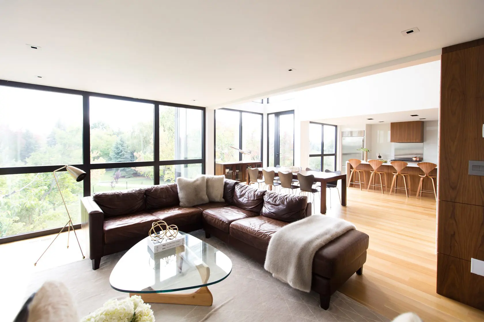 Spacious living room with leather sectional and panoramic windows.