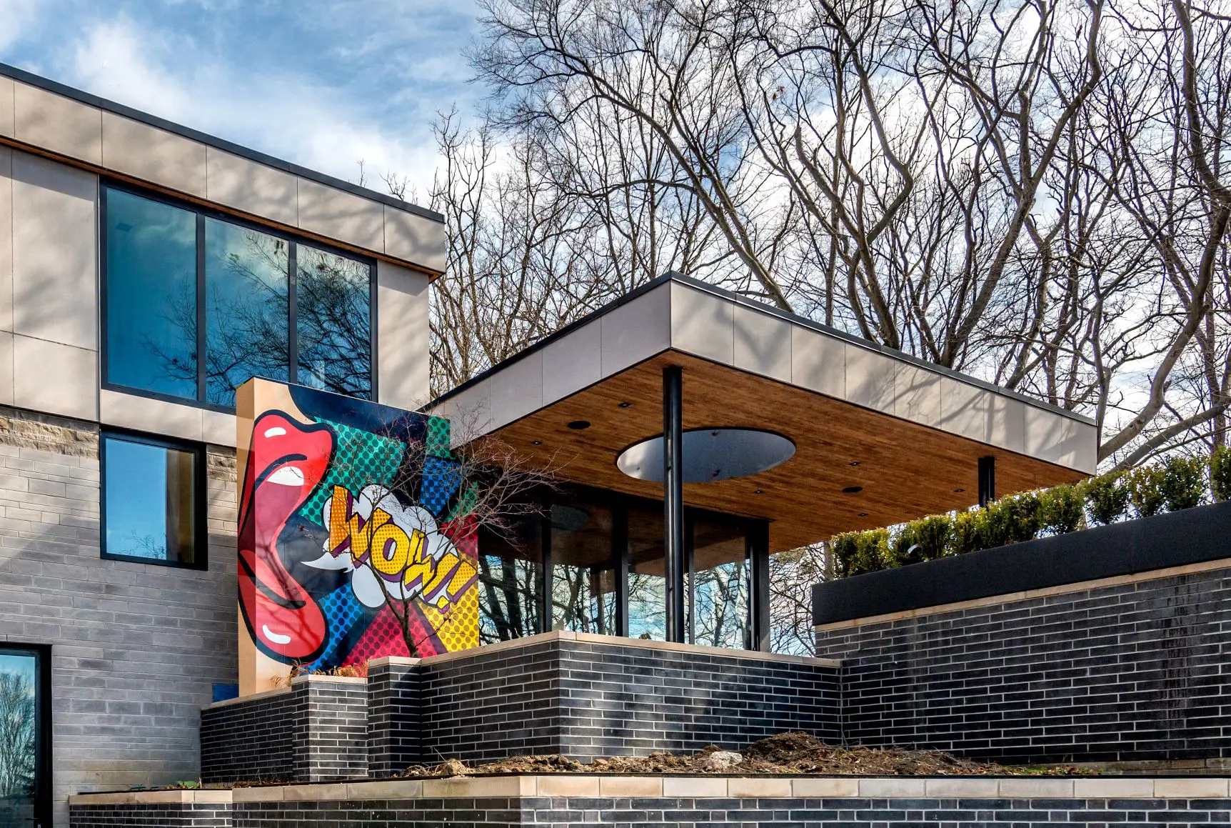 Contemporary house with pop art mural and wood-covered terrace.