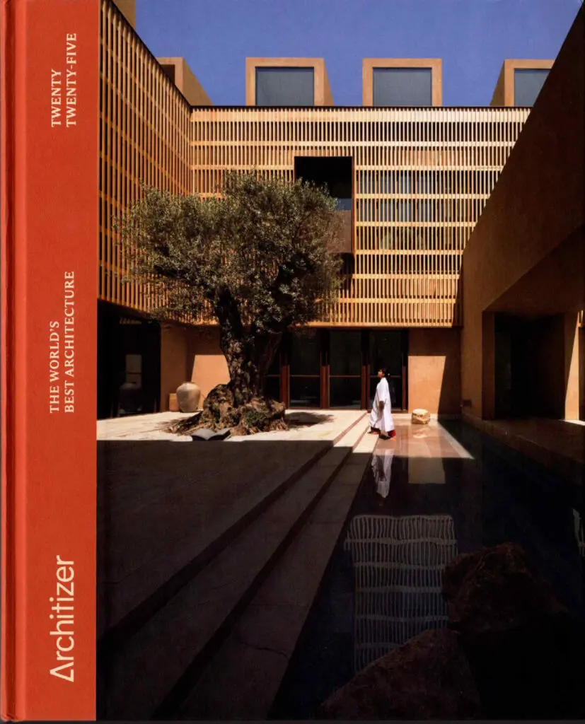 Modern architectural courtyard with sculptural tree and reflective pool featured on Architizer’s “World’s Best Architecture” cover.