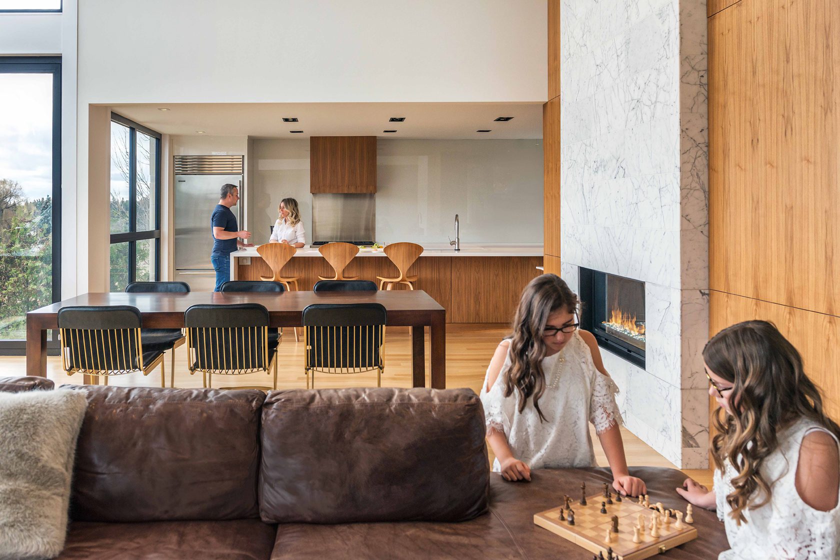 The interior of a custom built home designed by FrankFranco architects featuring wood millwork and brown leather sofas. Are you looking for an architect for your new home build. Here's how to choose the right architect.