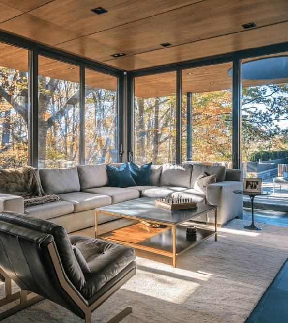 An open concept living space featuring floor to ceiling windows as a part of elevating interior lighting design